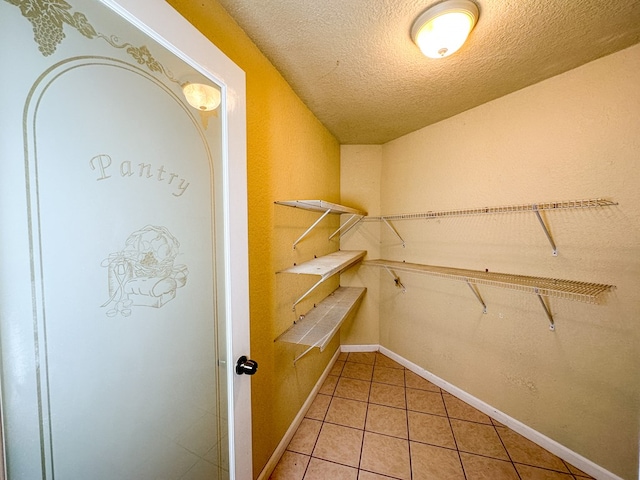 walk in closet with light tile patterned flooring