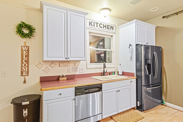 kitchen with white cabinetry, stainless steel appliances, and sink