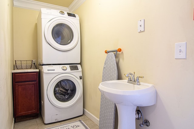 laundry area with sink, cabinets, stacked washer and clothes dryer, light tile patterned floors, and crown molding