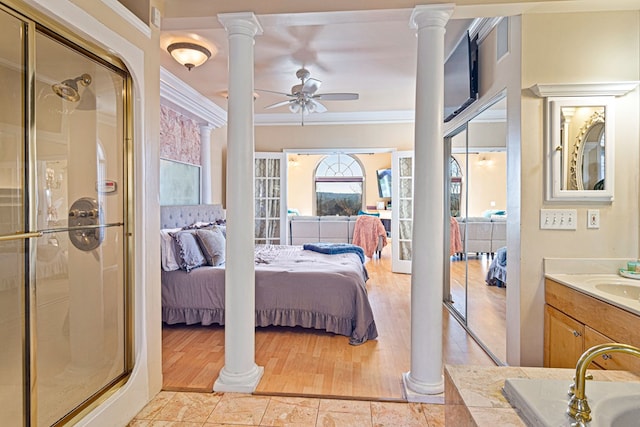 bedroom with ceiling fan, ornamental molding, sink, and decorative columns