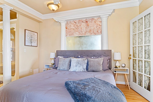 bedroom featuring crown molding, hardwood / wood-style floors, and ornate columns