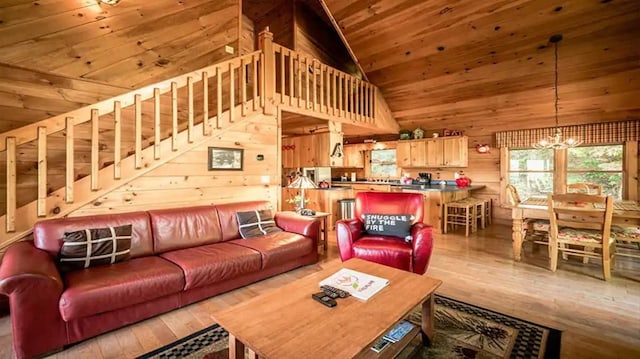 living room with wooden walls, a chandelier, wooden ceiling, high vaulted ceiling, and light hardwood / wood-style flooring