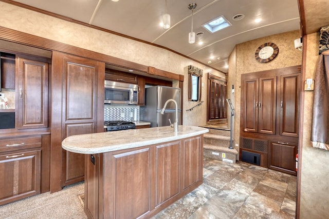 kitchen with appliances with stainless steel finishes, light stone counters, ornamental molding, a center island with sink, and decorative light fixtures