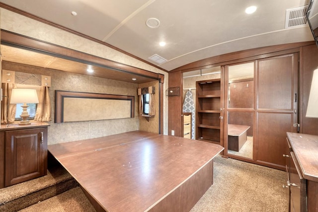 office area featuring light colored carpet, crown molding, and vaulted ceiling