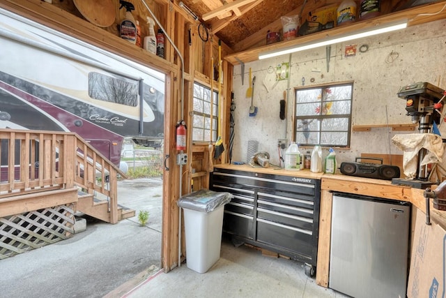 kitchen featuring stainless steel refrigerator, a healthy amount of sunlight, and lofted ceiling