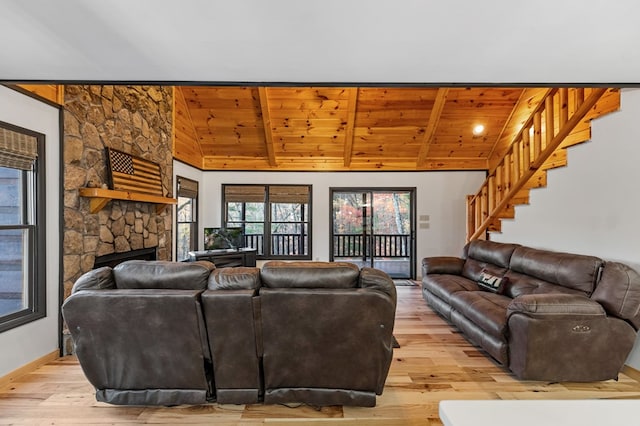 living room with vaulted ceiling with beams, wood ceiling, a fireplace, and light wood-type flooring