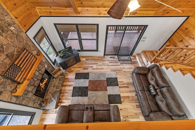 living room with hardwood / wood-style floors, wood ceiling, a fireplace, and beamed ceiling