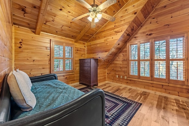 bedroom with lofted ceiling with beams, wooden ceiling, wooden walls, and light hardwood / wood-style floors