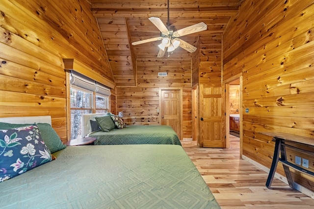 bedroom with ceiling fan, high vaulted ceiling, light hardwood / wood-style flooring, and wood walls