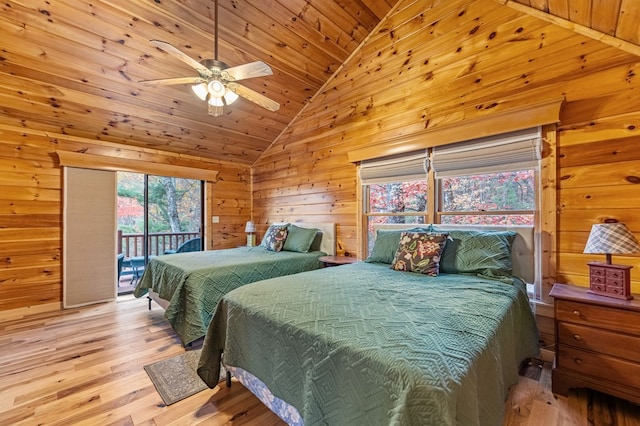 bedroom featuring wood ceiling, light hardwood / wood-style flooring, access to exterior, vaulted ceiling, and wood walls