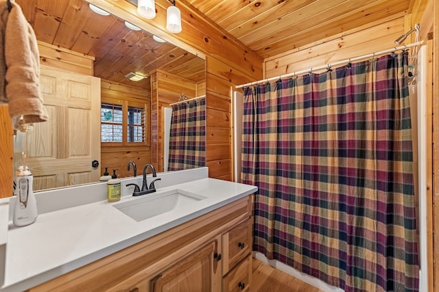 bathroom with vanity, wooden walls, and wooden ceiling