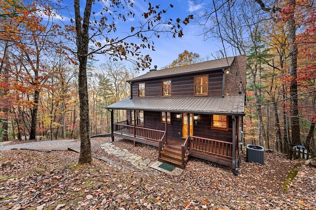 log cabin featuring central AC unit and a porch