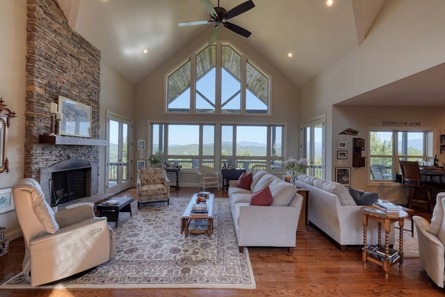 living room with a mountain view, dark hardwood / wood-style flooring, high vaulted ceiling, and ceiling fan