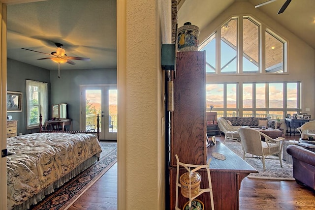 bedroom featuring dark wood-type flooring, high vaulted ceiling, french doors, ceiling fan, and access to exterior