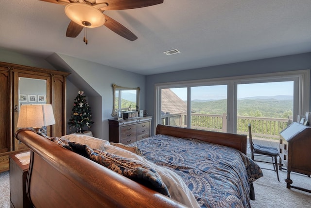 bedroom with ceiling fan, light colored carpet, a mountain view, and a textured ceiling