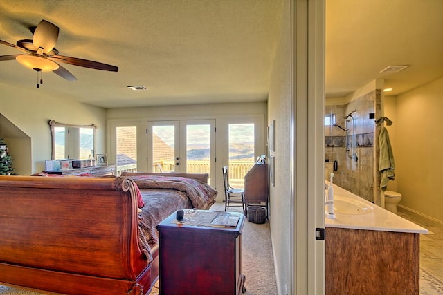 carpeted bedroom featuring access to exterior, french doors, multiple windows, and ceiling fan