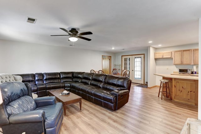 living room with french doors, light hardwood / wood-style flooring, and ceiling fan