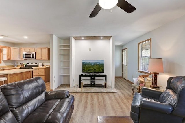 living room with light hardwood / wood-style flooring, ceiling fan, and built in features