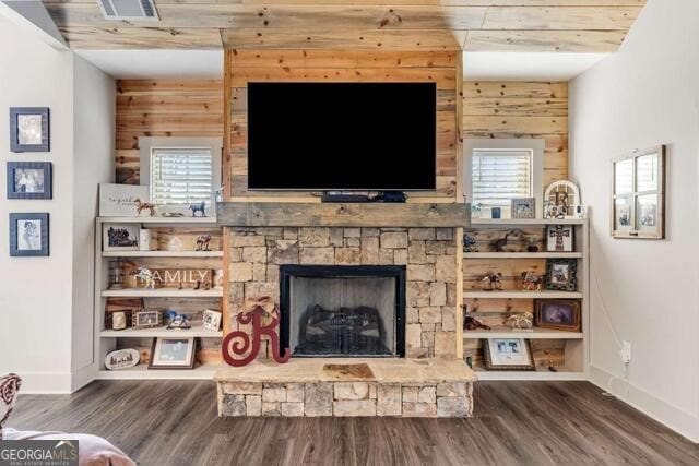 living room featuring a wealth of natural light, wood walls, a fireplace, and hardwood / wood-style flooring