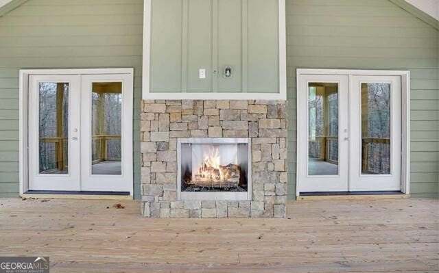 doorway to property featuring a fireplace, french doors, and a deck