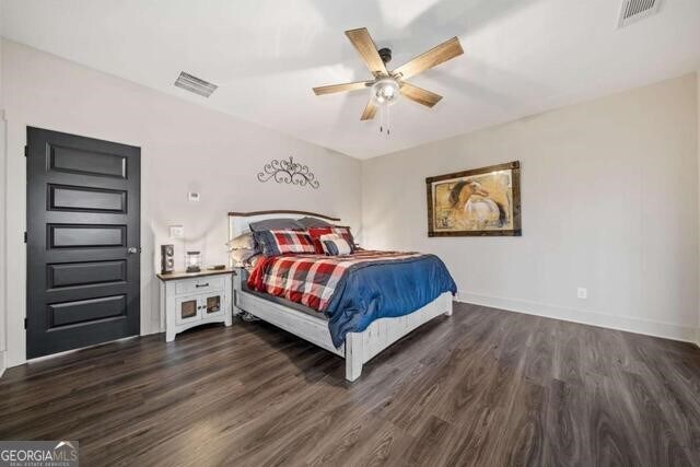 bedroom with ceiling fan and dark hardwood / wood-style floors