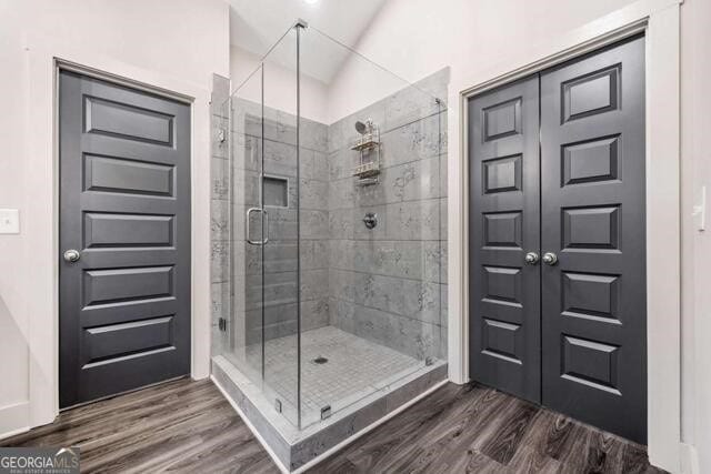 bathroom featuring hardwood / wood-style floors and a shower with shower door