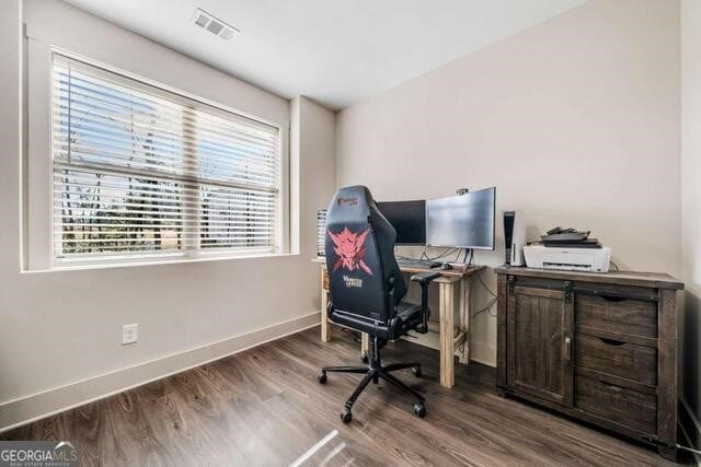 home office with a healthy amount of sunlight and hardwood / wood-style flooring