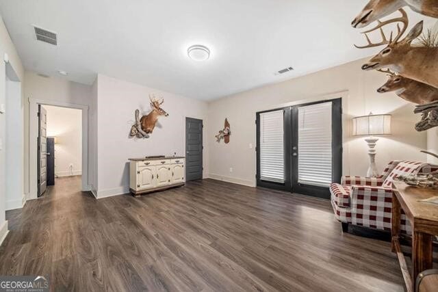 living area with dark hardwood / wood-style flooring and french doors