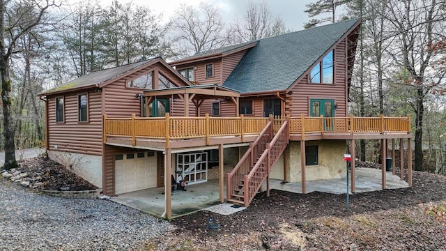 back of house with a garage, a deck, and a patio