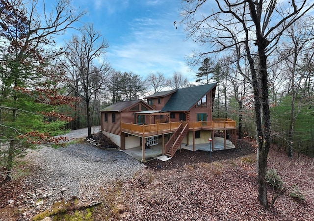 rear view of house featuring a patio area and a wooden deck