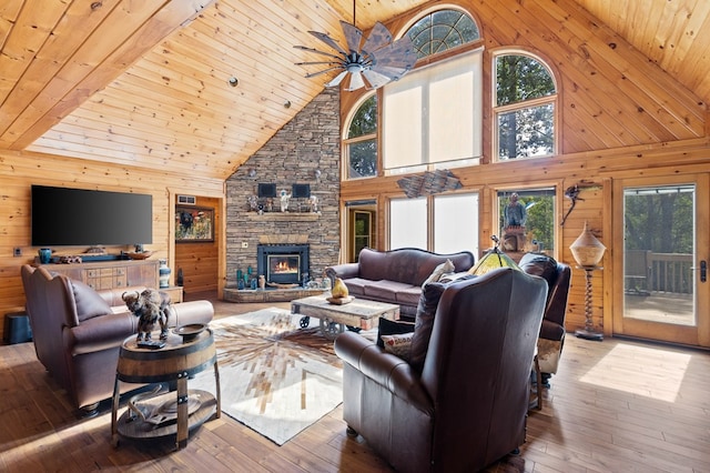 living room with high vaulted ceiling, plenty of natural light, and a fireplace