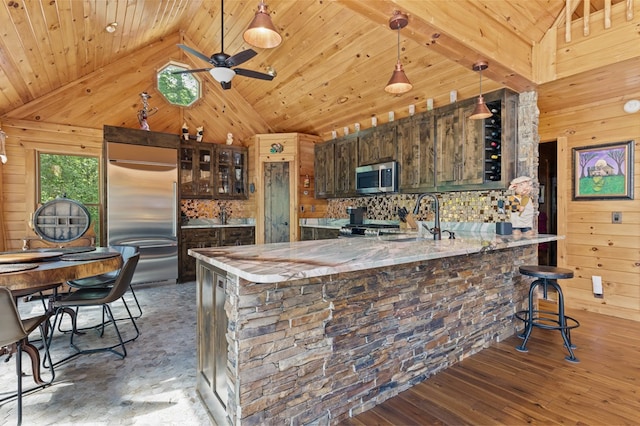 kitchen featuring ceiling fan, stainless steel appliances, hardwood / wood-style floors, and high vaulted ceiling