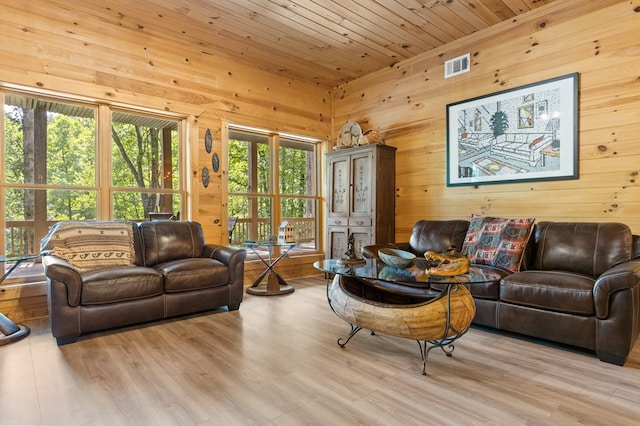 living room featuring light hardwood / wood-style flooring, wood walls, and wooden ceiling