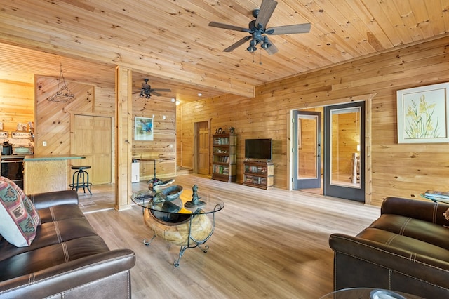 living room featuring light hardwood / wood-style flooring, wood walls, and ceiling fan