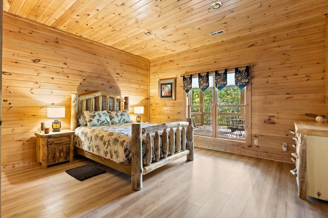 bedroom with wooden ceiling, wood walls, and light hardwood / wood-style flooring