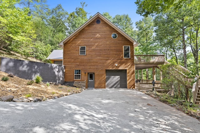 view of front facade with a garage and a wooden deck