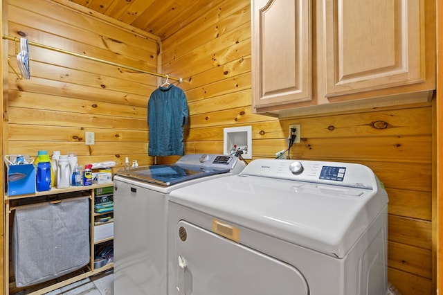 laundry room featuring cabinets, wooden walls, separate washer and dryer, and wood ceiling