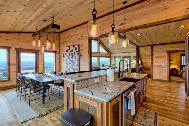 kitchen featuring wood ceiling, decorative light fixtures, light hardwood / wood-style flooring, and light stone counters