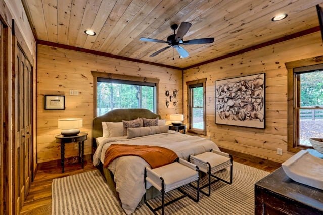 bedroom with ceiling fan, wooden walls, light hardwood / wood-style flooring, and wooden ceiling