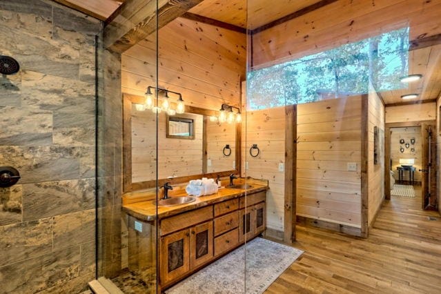 bathroom featuring walk in shower, vanity, wooden walls, and hardwood / wood-style floors