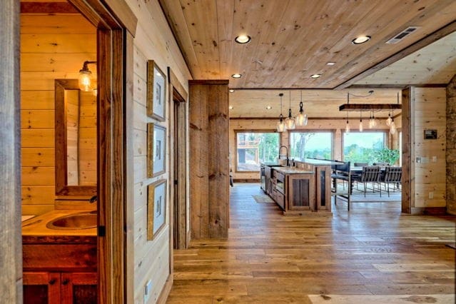 hallway with dark wood-type flooring, wood walls, and wooden ceiling