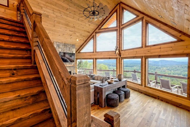 living area with high vaulted ceiling, wooden ceiling, and wood finished floors