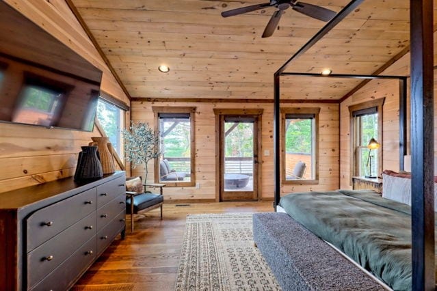 bedroom with wooden ceiling, hardwood / wood-style flooring, wooden walls, access to exterior, and lofted ceiling