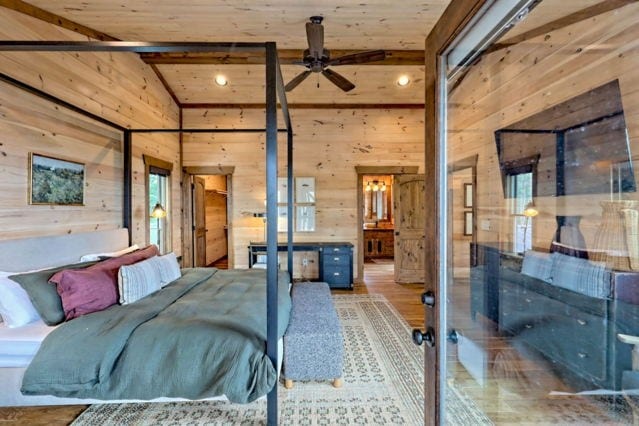bedroom featuring wood ceiling, wood finished floors, wood walls, and lofted ceiling