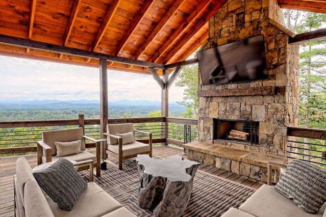 deck with an outdoor living space with a fireplace
