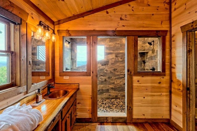 bathroom featuring vanity, wood-type flooring, wooden ceiling, walk in shower, and vaulted ceiling