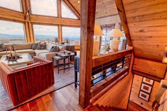 living area featuring wood walls, wood finished floors, and lofted ceiling
