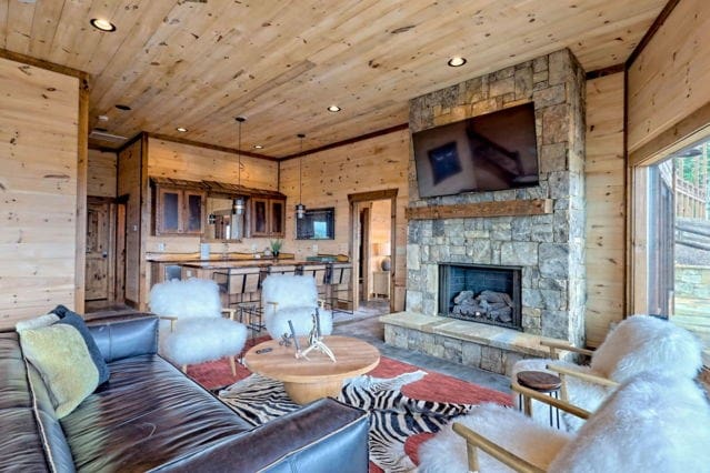 living room with a fireplace, wooden walls, and wooden ceiling