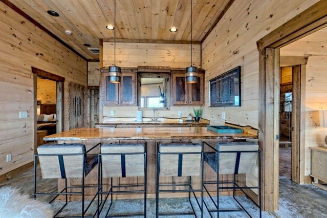 kitchen featuring wooden walls, hanging light fixtures, and a breakfast bar