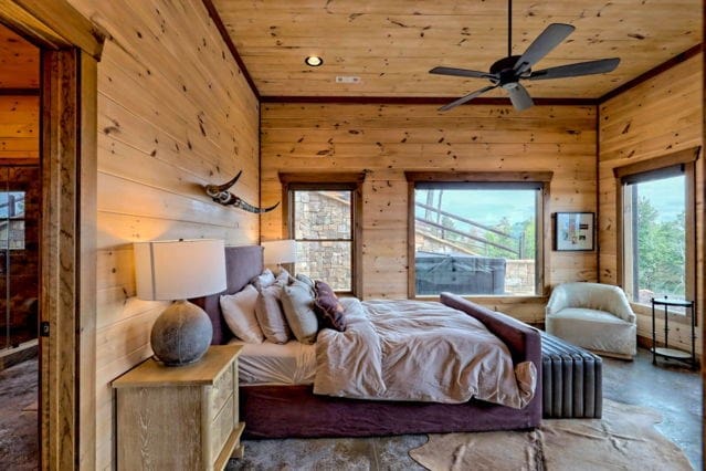 bedroom featuring wooden ceiling, wood walls, and concrete floors